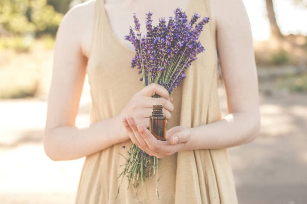 beautiful compliant photo of female hands holing essential oil bottle with fresh lavender stock image