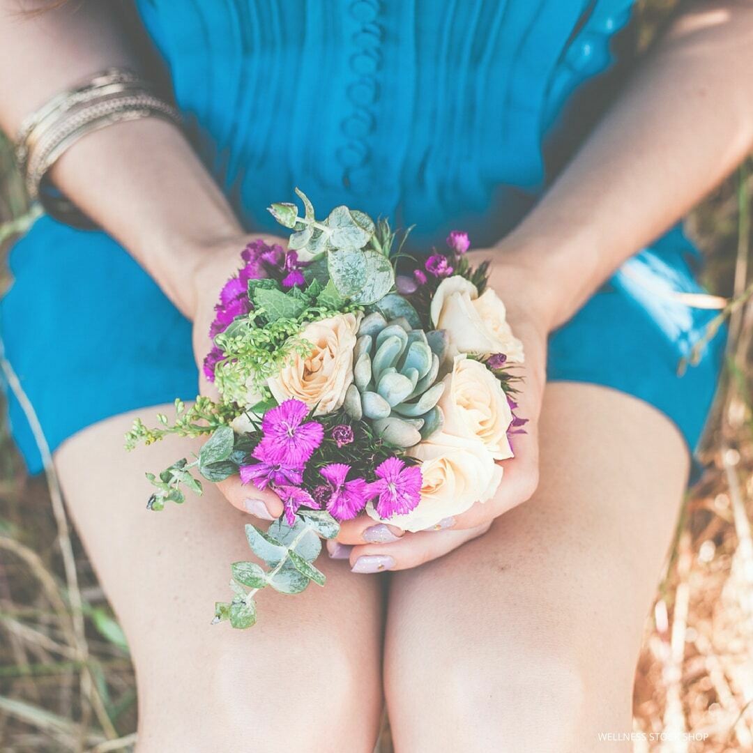 girl holding succulent flower bouquet in lap with blue dress stock photo social media image